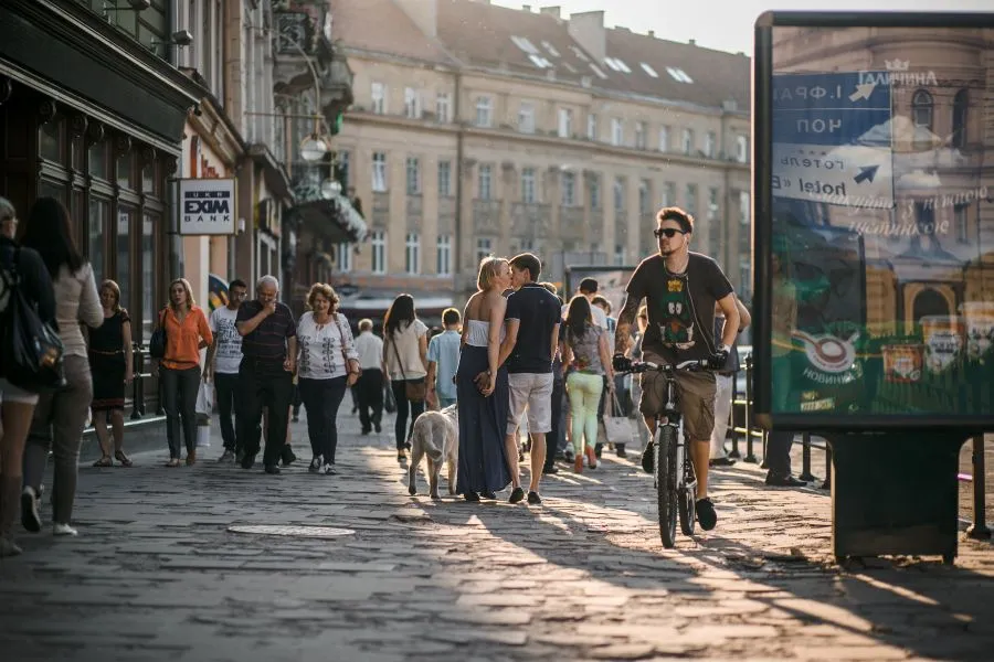 Urban crowd passing by a DOOH advertising screen, illustrating DOOH Audience Insights in real-world environments