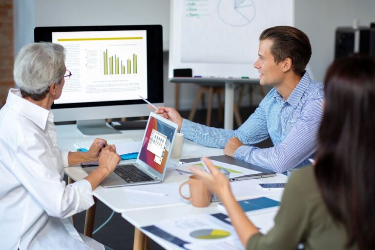 Team reviewing campaign data and charts during a DOOH Performance Reporting strategy meeting